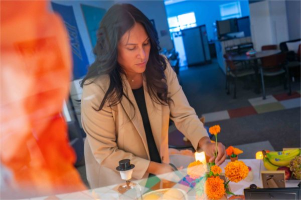   A person prepares a Day of the Dead altar.